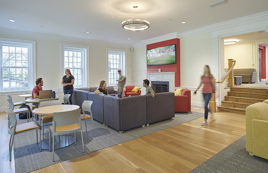 Interior of a campus common room with students sitting and talking